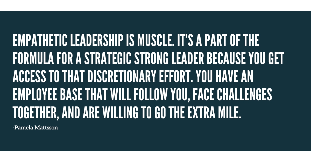 A businessman stands before a team of twenty coworkers, leveraging his business acumen to drive change as he speaks.